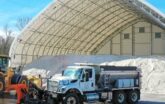 vehicles in front of a fabric sand and salt building