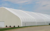 Extra long fabric structure with metal end wall