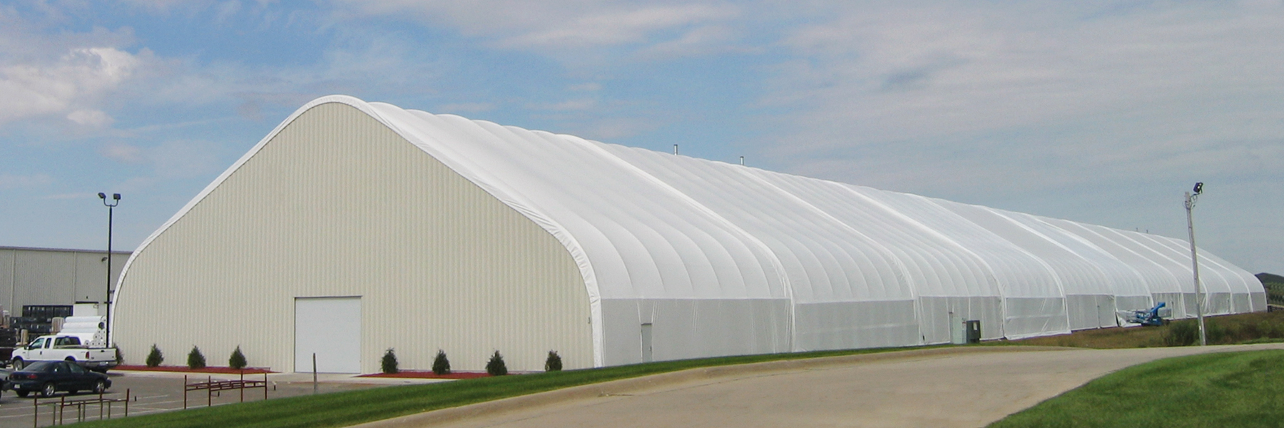 Extra long fabric structure with metal end wall