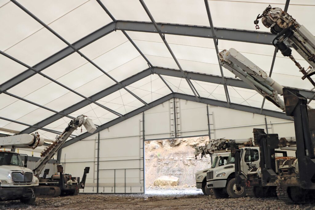 multiple trucks parked inside fabric beam building