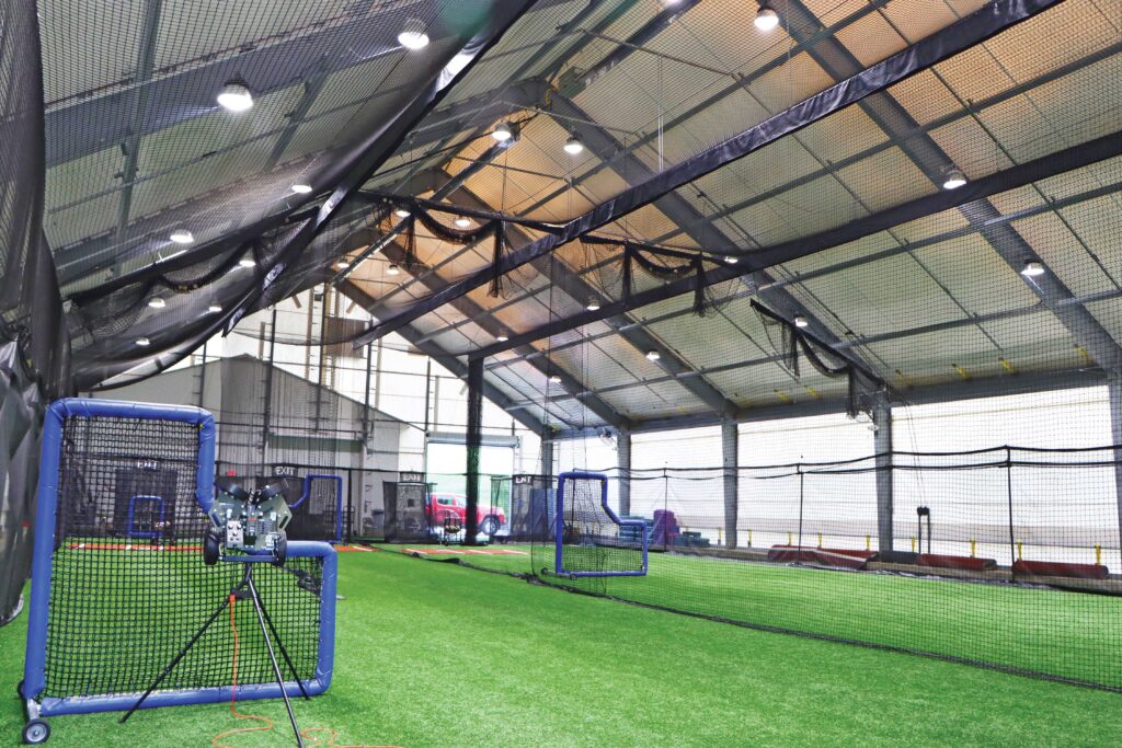 batting cages on green turf under fabric building