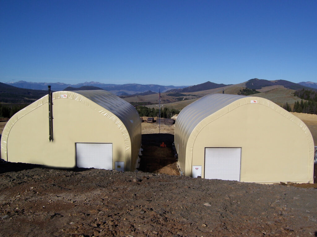 two tan fabric structures on arid landscape
