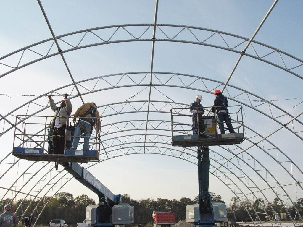 workers constructing a truss building on site