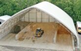 outside fabric sand and salt storage building with loader