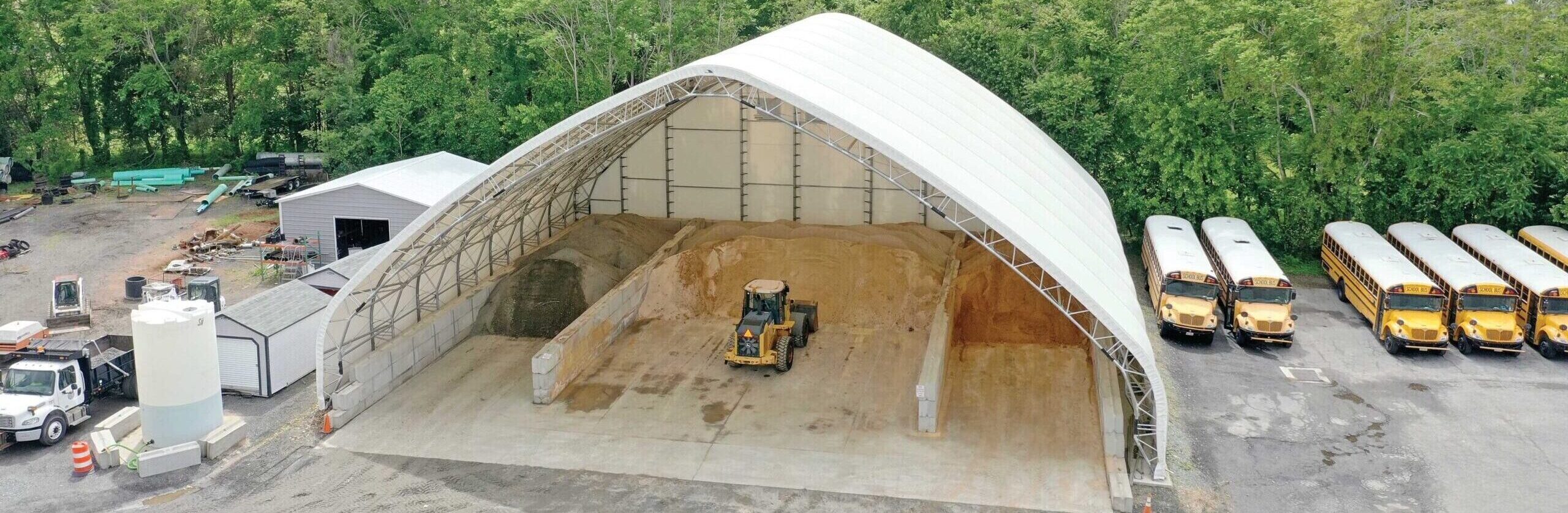 outside fabric sand and salt storage building with loader