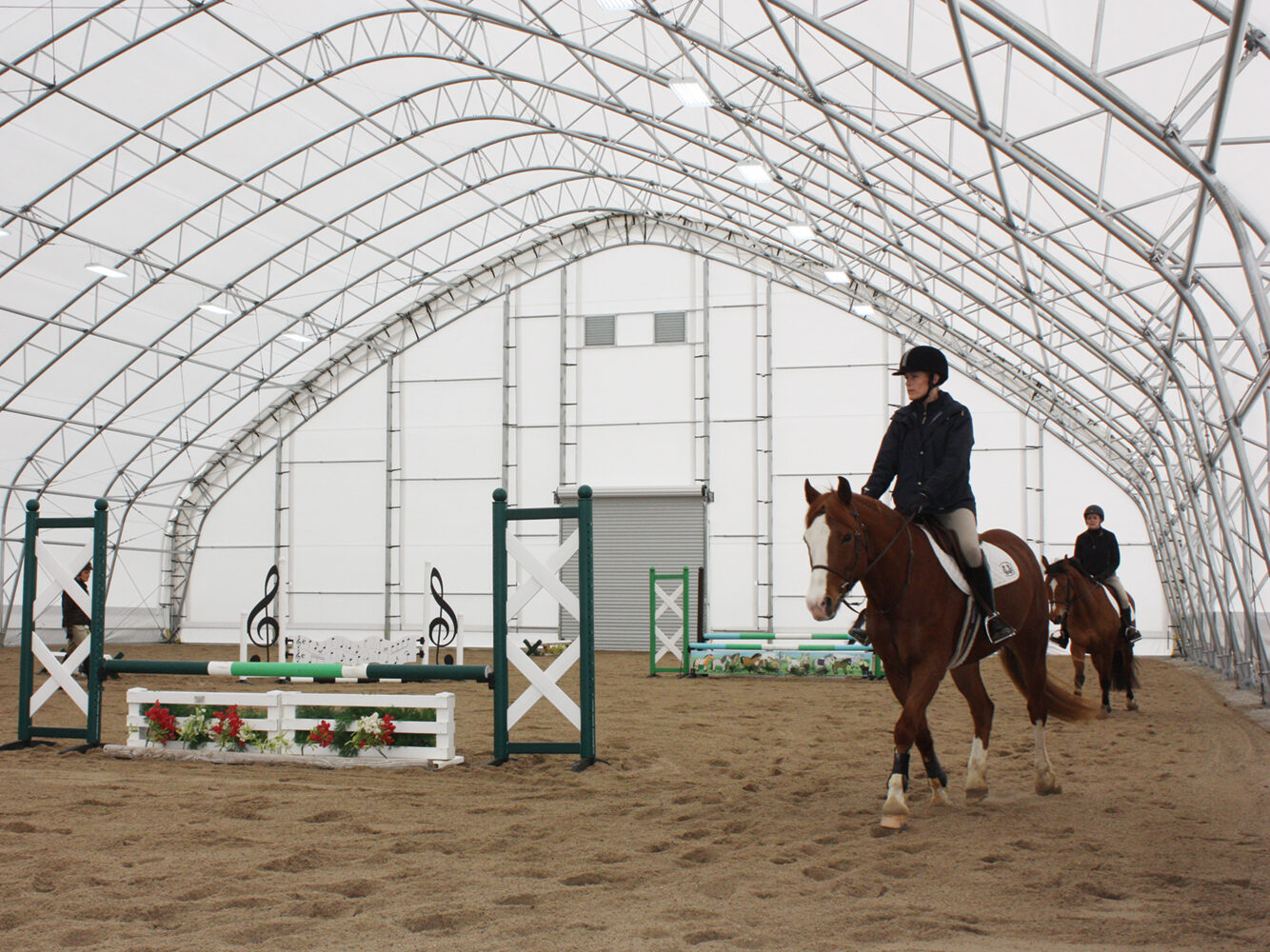 people riding horses inside equine building