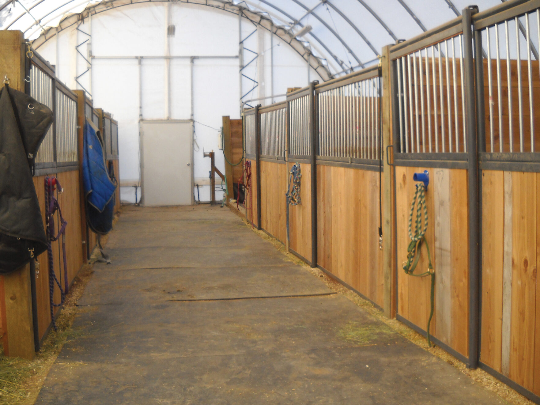 wooden horse stalls inside a fabric building