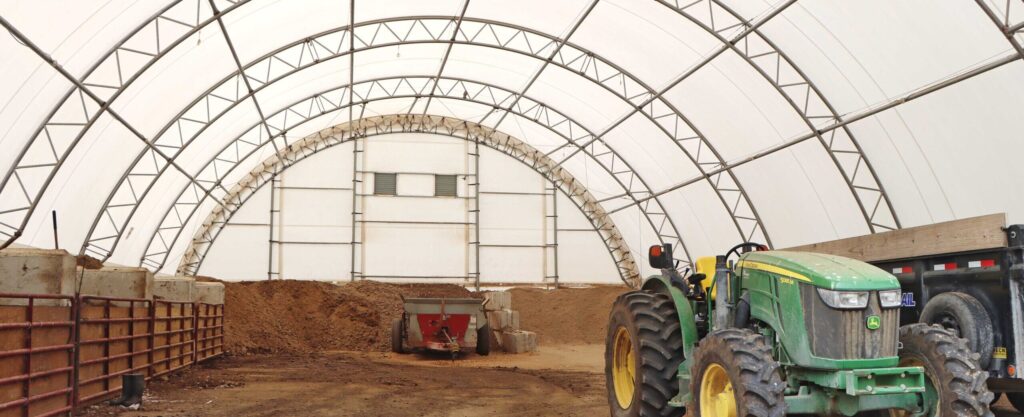tractor and stored material inside fabric structure