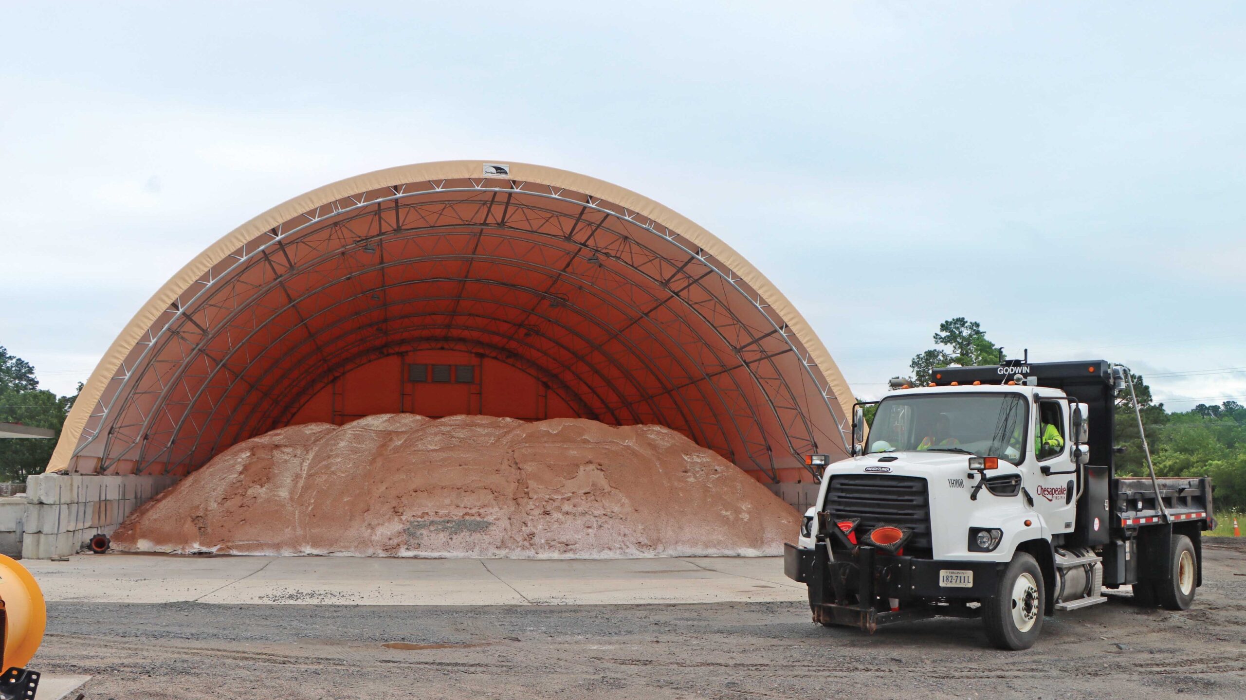 Fabric truss building housing sand and salt with truck in front