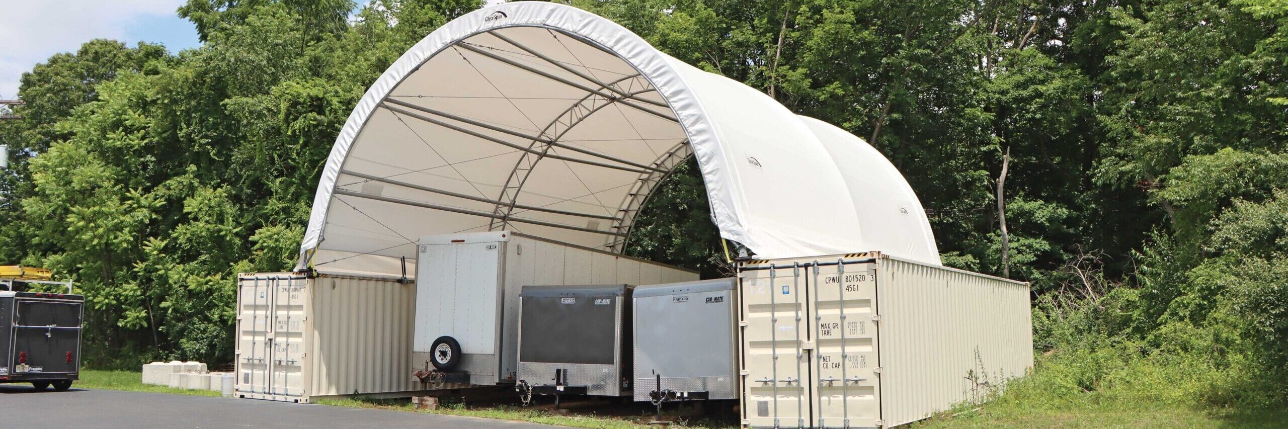 fabric tent shed with trailers stored underneath