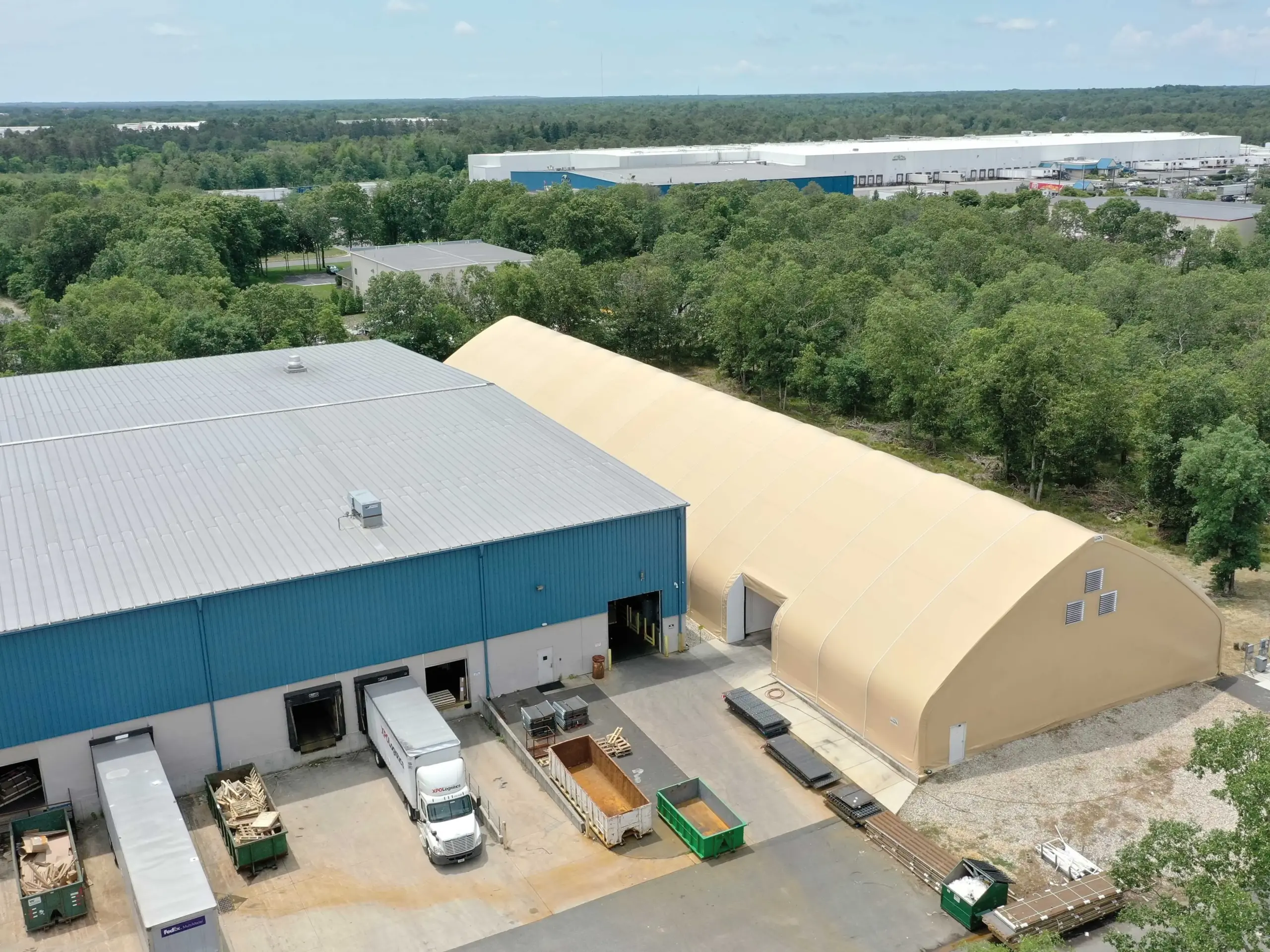 a structure with metal building cladding next to one with fabric building cladding