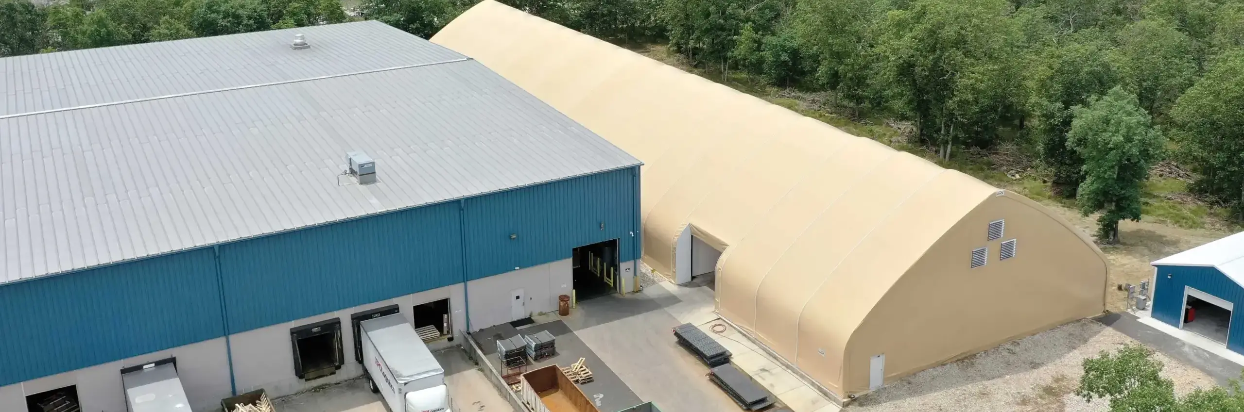 a structure with metal building cladding next to one with fabric building cladding