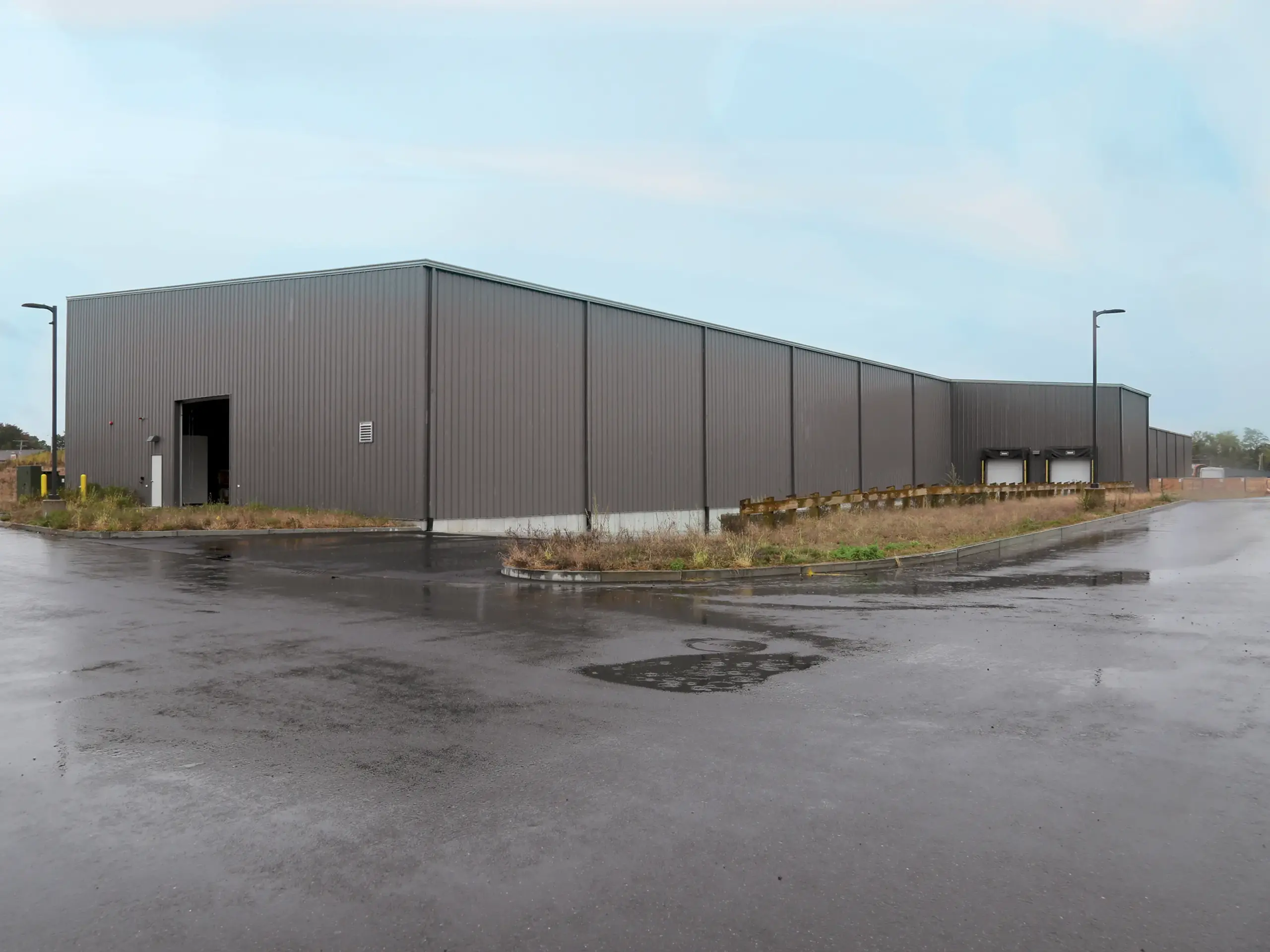 a gray metal warehouse building in an L-shaped layout