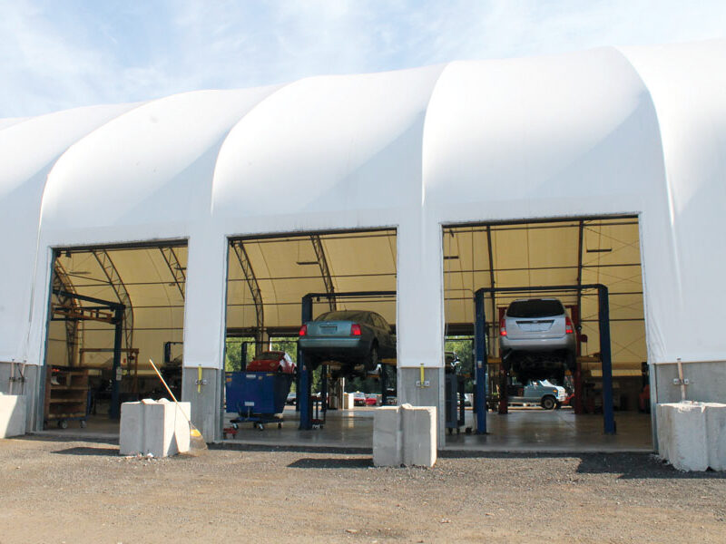 Fabric automotive building with open bays in the side
