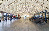 cars undergoing maintenance inside a fabric automotive building