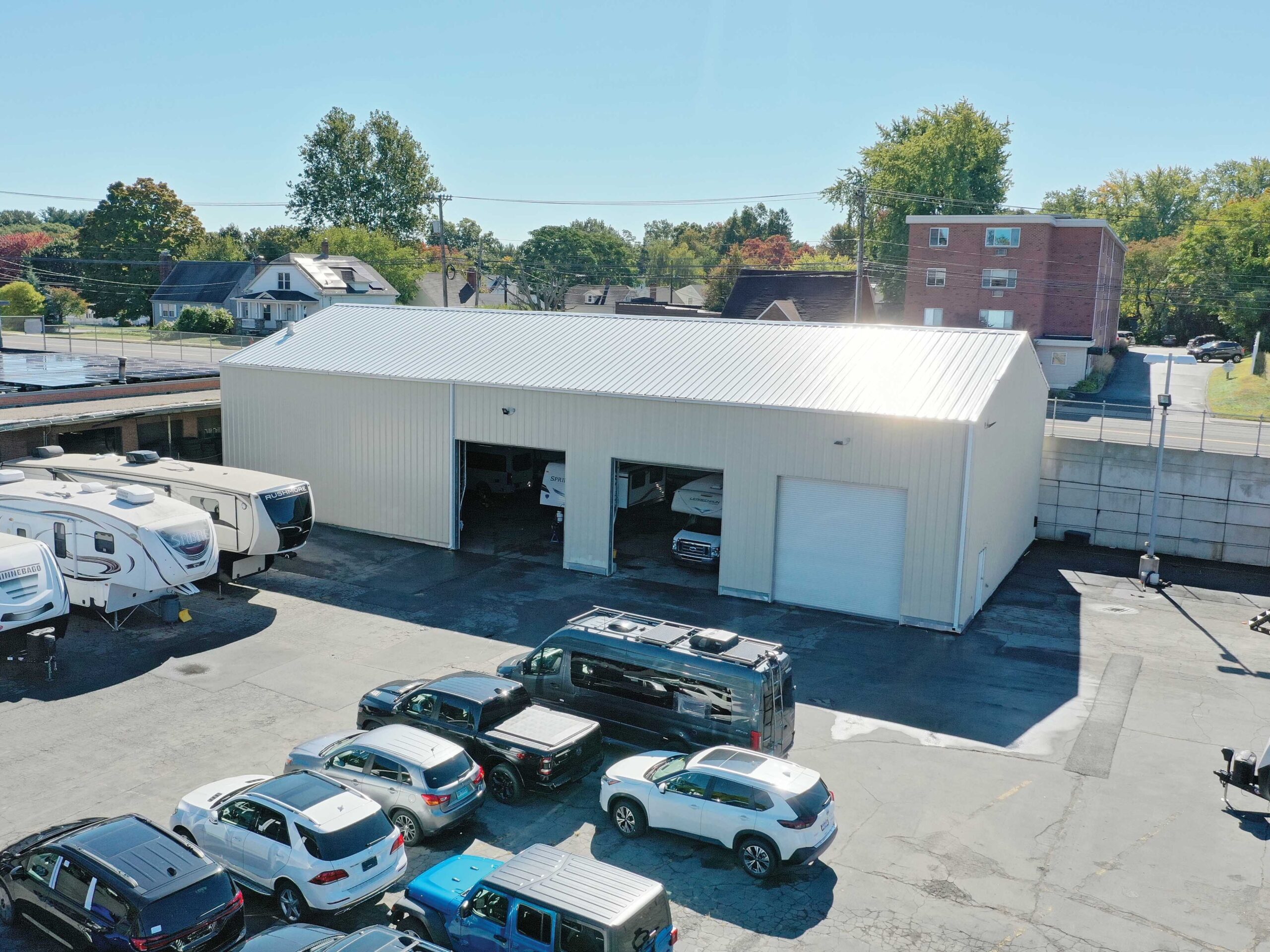 Metal automotive building with cars parked outside