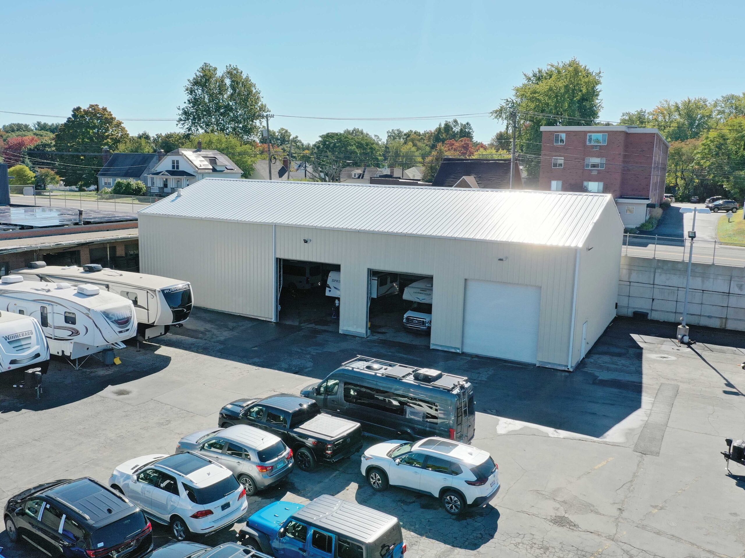 Metal automotive building with cars parked outside