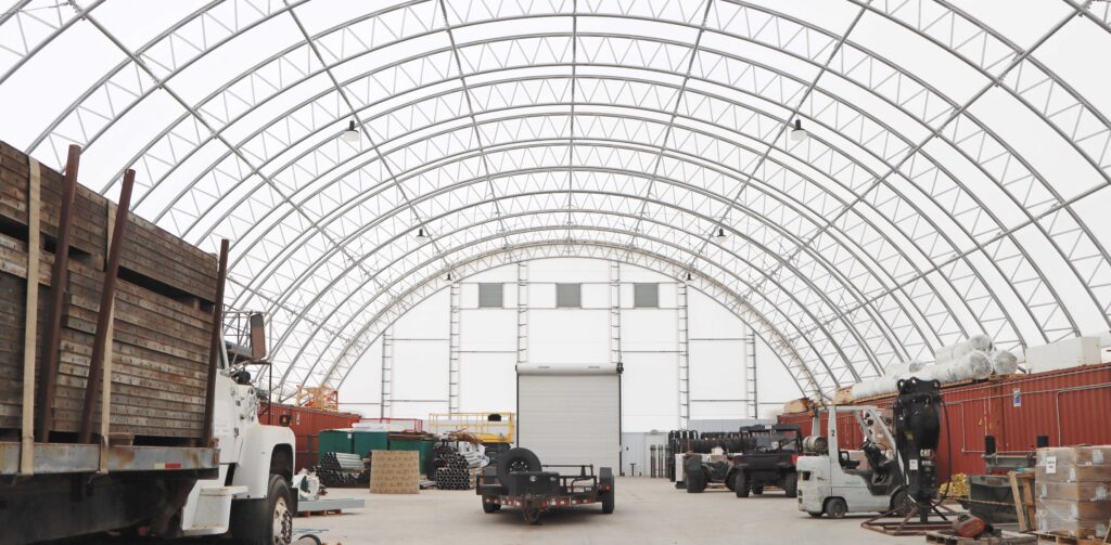 Complete interior view of a ClearSpan HD Container Building with stored vehicles and goods